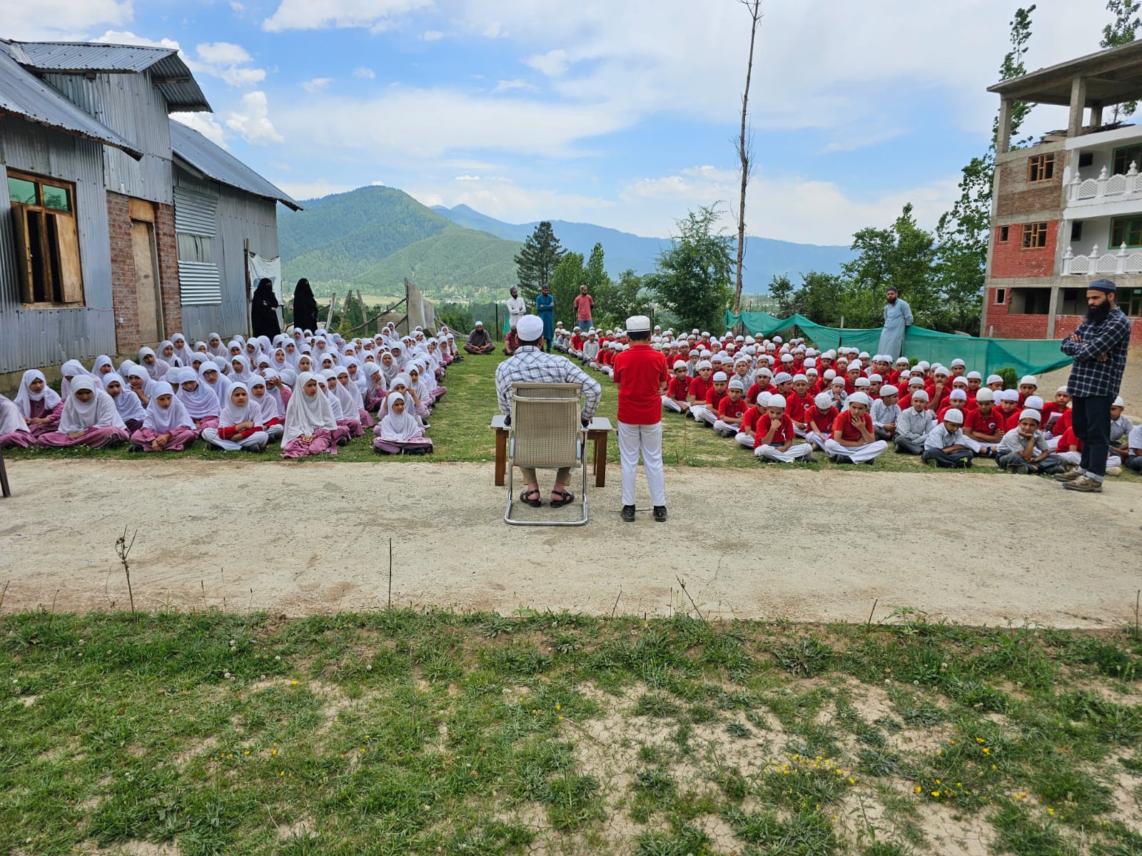 Morning assembly on the school ground, with the Lolab hills beyond.