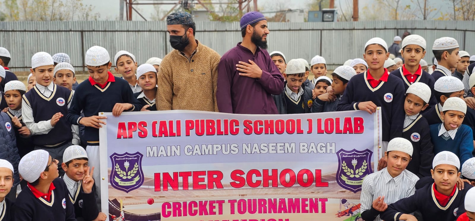 The Inter-School Cricket Tournament champions banner held up by the winning squad.